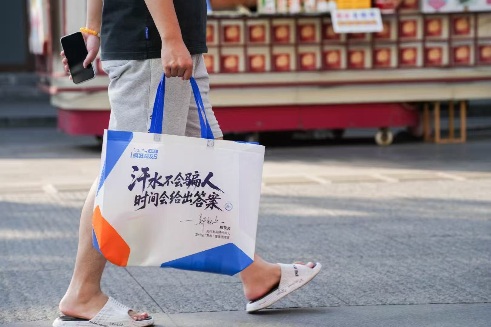 百店发支付宝助威袋为南京队加油大报恩寺遗址上演古今碰撞，支付宝碰一下点亮琉璃宝塔