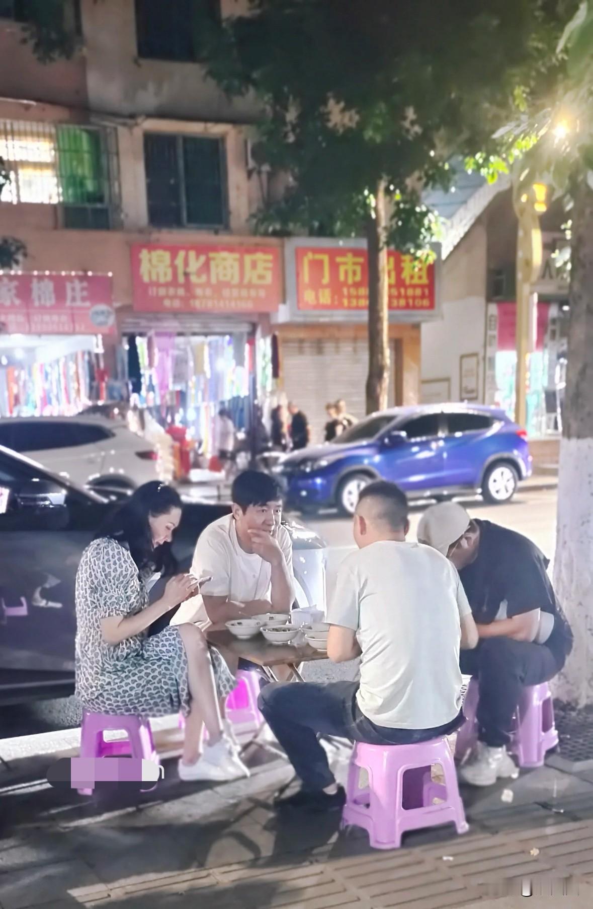 网友偶遇郭晓东程莉莎夫妇吃路边摊，超接地气！
程莉莎翘着二郎腿低头看手机，郭晓东