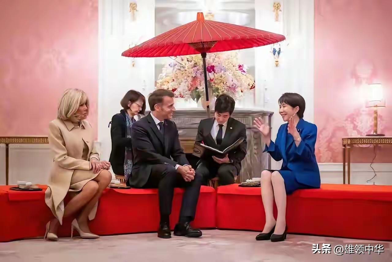 “独一无二”的会晤场景布置，一排红沙发坐着，一顶红伞撑着，背景墙采用两边粉红色，