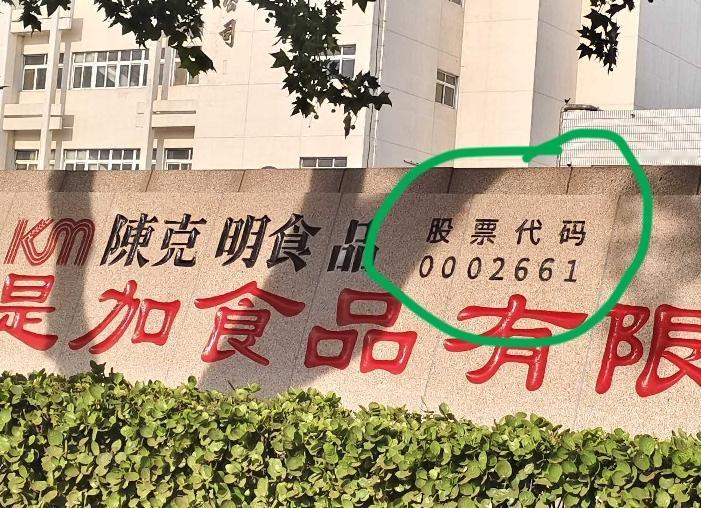 即墨区墨城路300号克明食品旗下亚是加食品有限公司门口的新门牌石雕刻的股票代码是