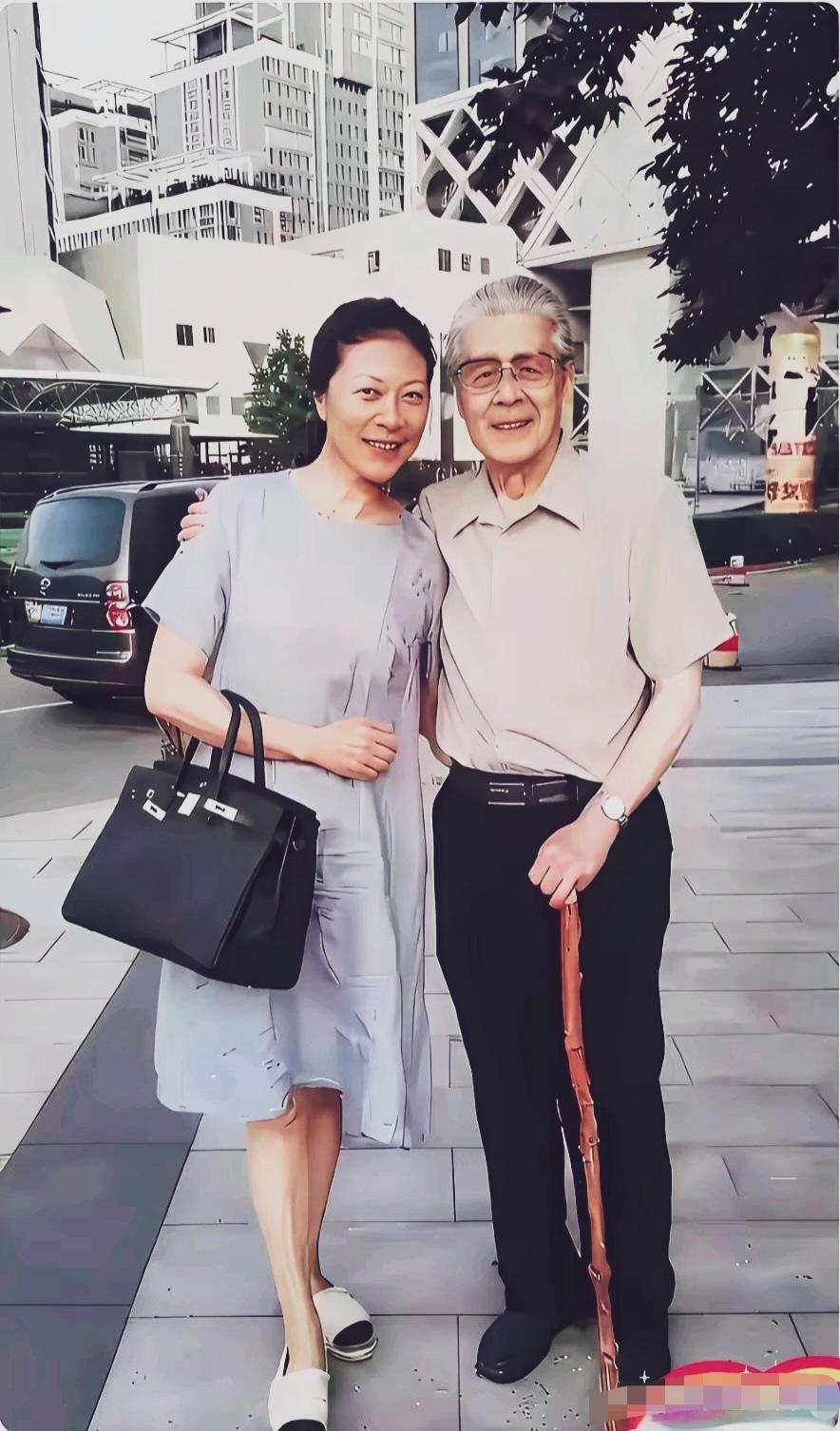 左边是岳红，右边的老者佩戴眼镜、手持木质拐杖，神态温和儒雅，他是谁？