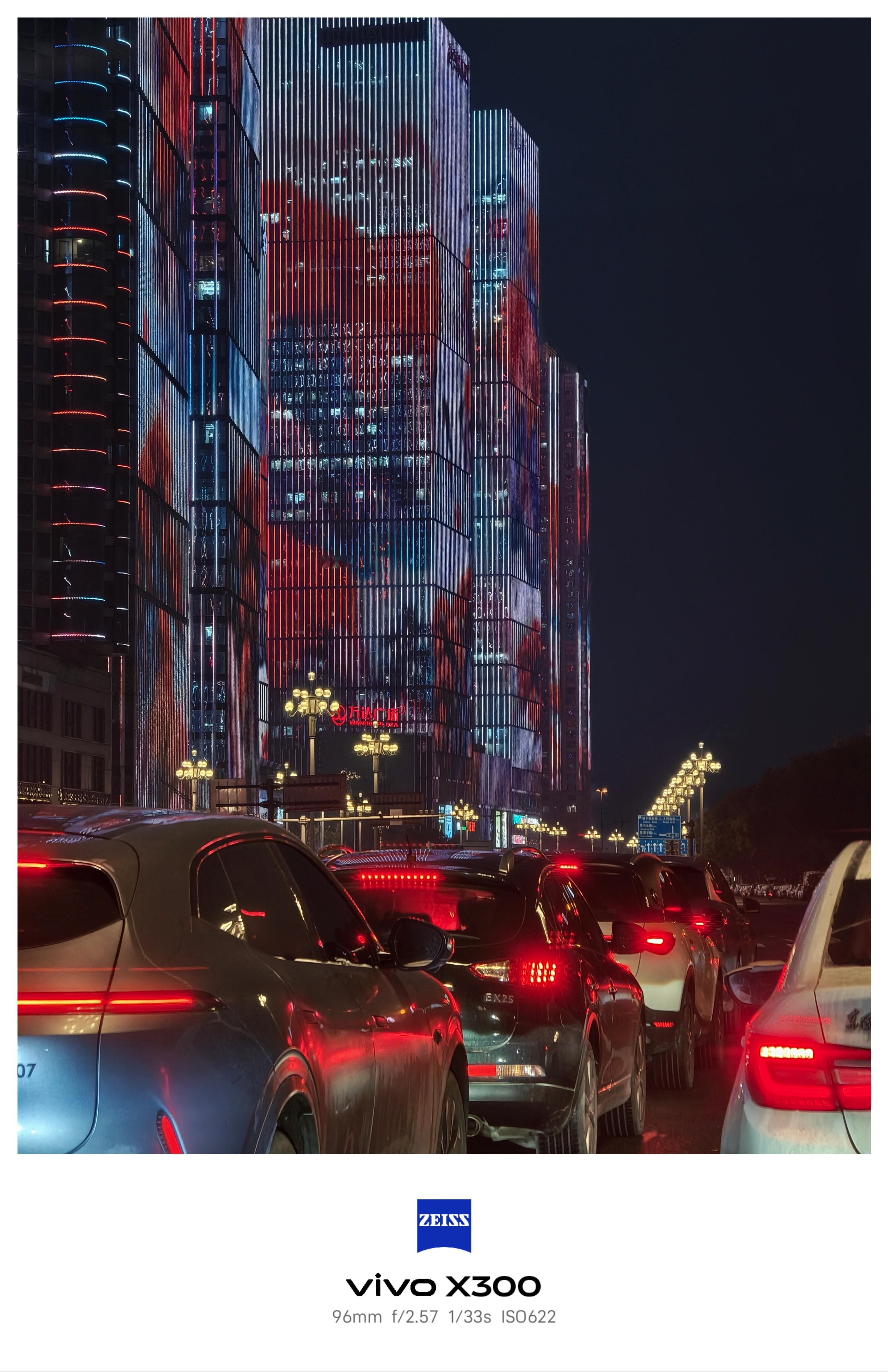 这张照片由vivo X30拍摄，96mm长焦焦距在紧凑构图中放大了楼宇灯光的视觉