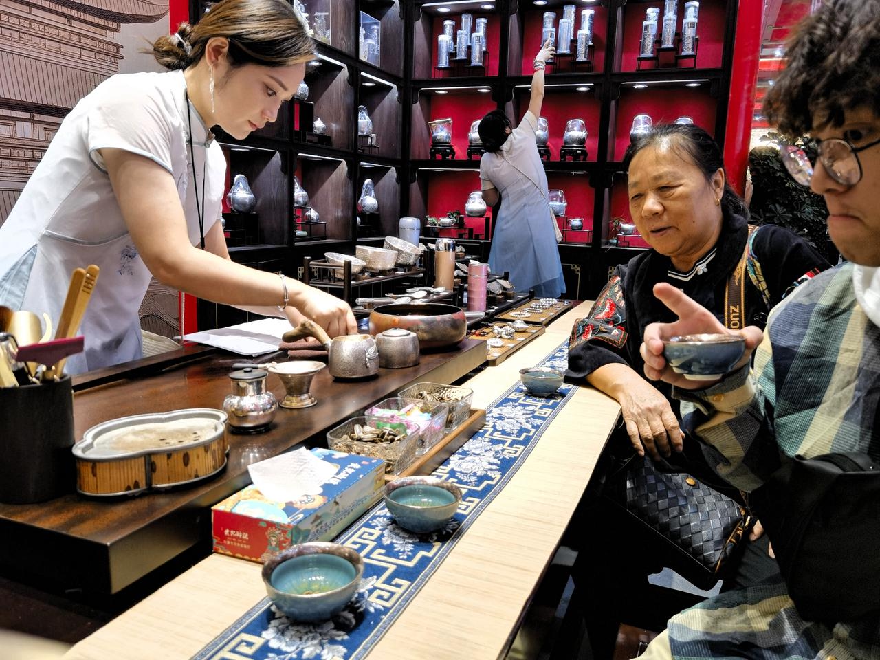 走在闹市青石板路上，人潮熙攘，暑气蒸腾，连脚步都带着几分燥热。

拐进一家商铺，