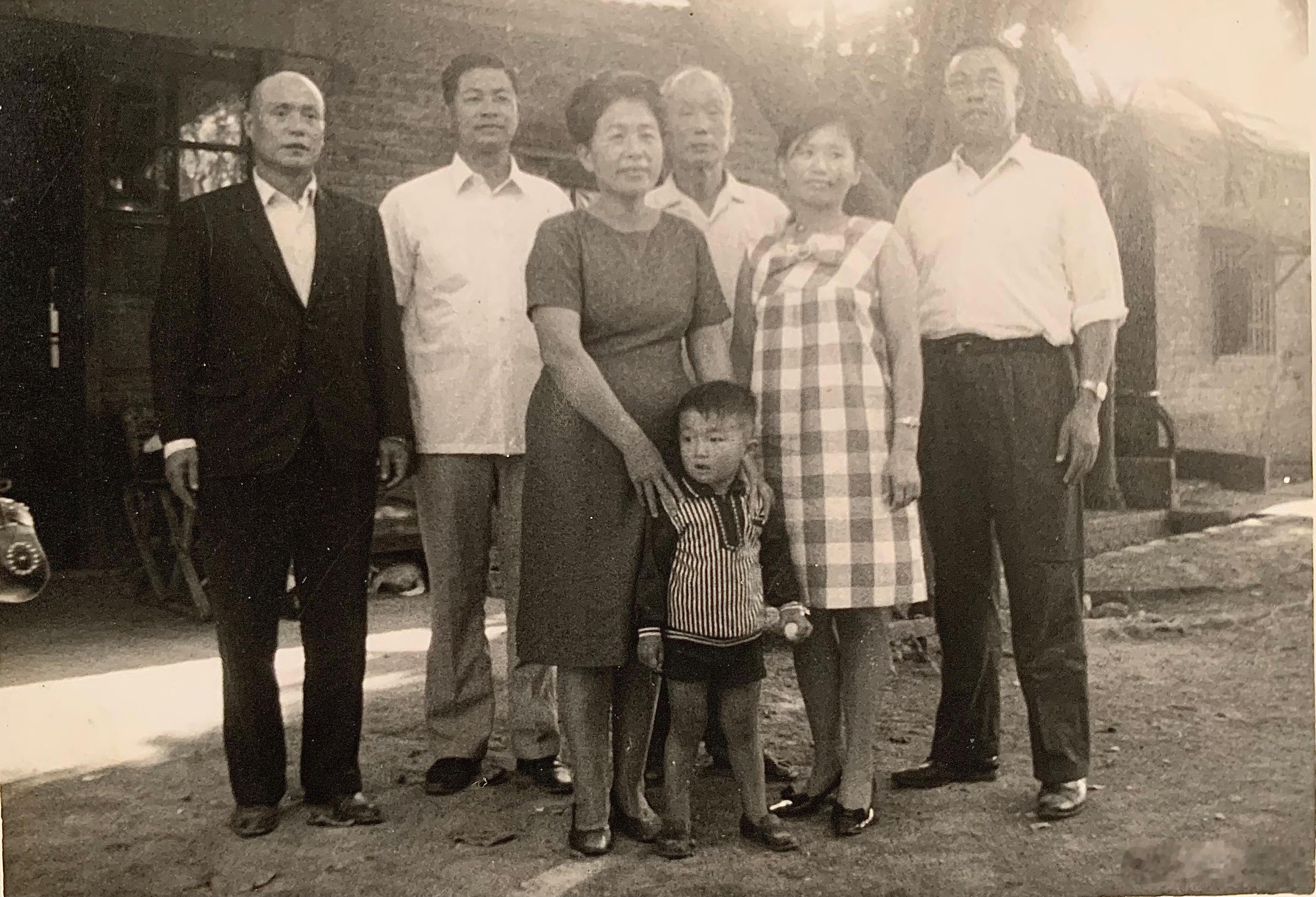 照片中的小朋友是我，大约两三岁，搭着我双肩的是我阿嬷（祖母），阿嬷后方的老人是我