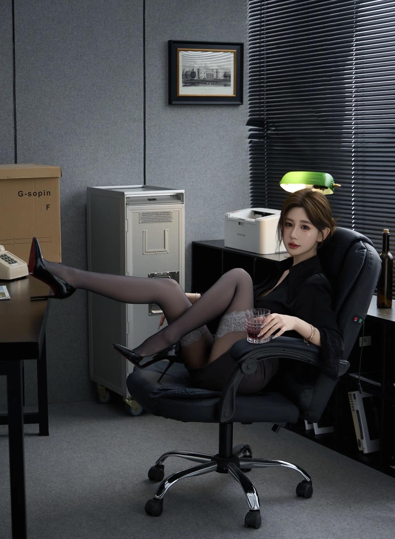 办公室里的优雅一刻，红领带与黑西装相得益彰，尽显女性魅力。