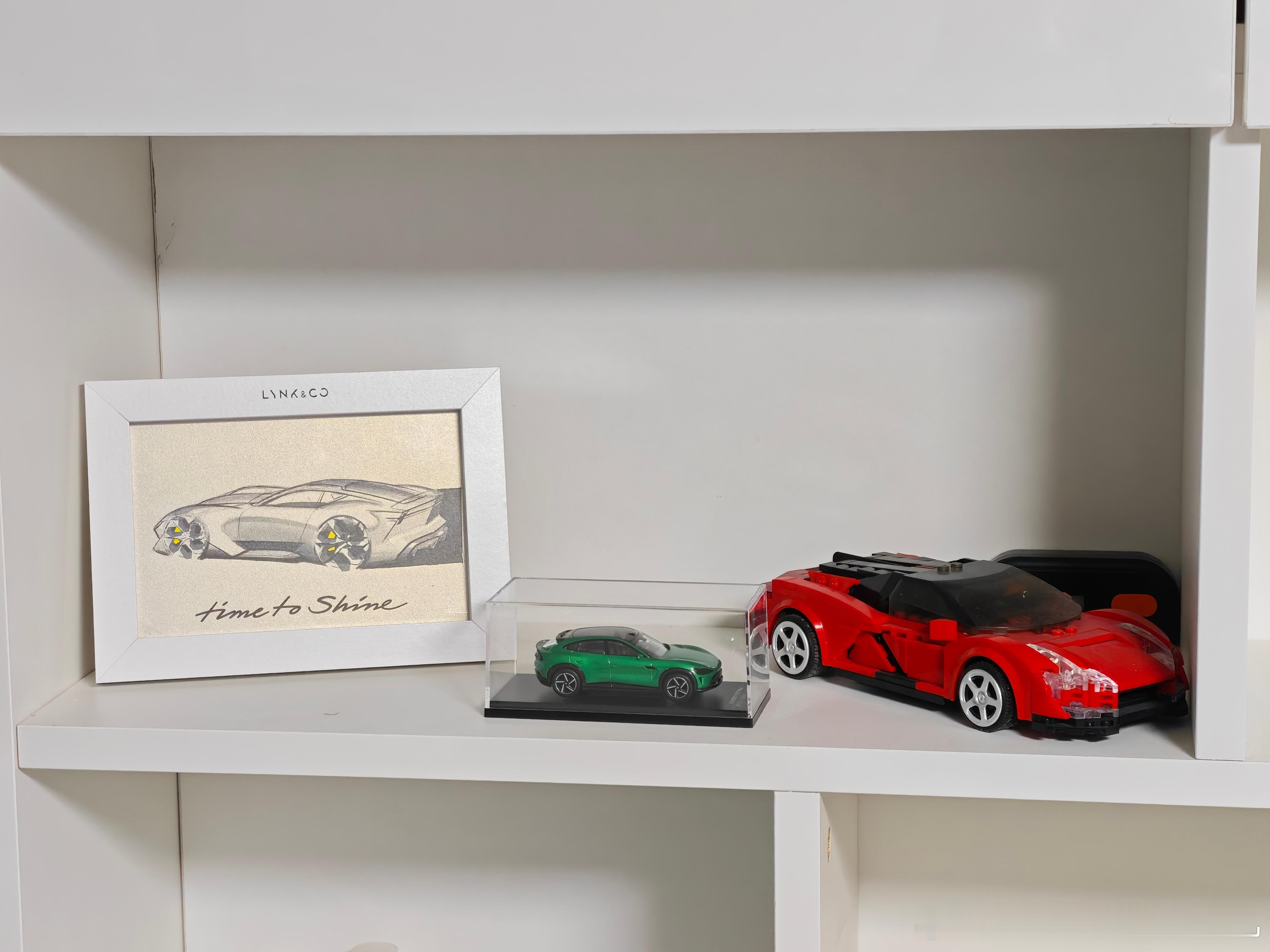 整理出来一个书柜格子，分别放了领克GT概念车绘图、小米YU7车模、仰望U9拼装积