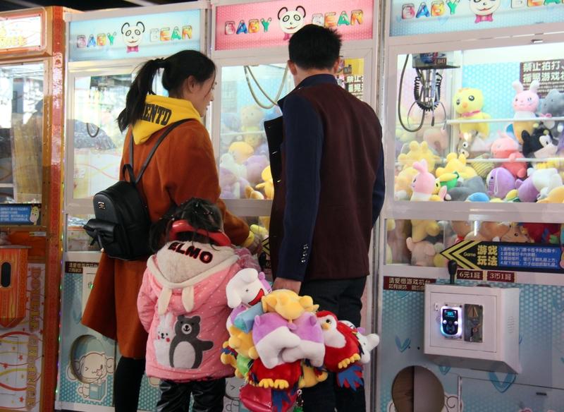 美国2岁男童趁父母没注意，偷偷爬进抓娃娃机里，警察、消防员等人站机器旁看其开心玩