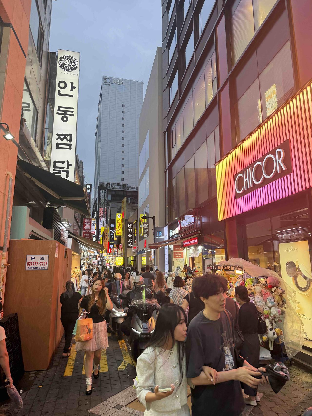 韩国首尔明洞霓虹亮起，人潮涌动！在熙攘街头与可爱玩偶撞个满怀，这热闹烟火气太迷人