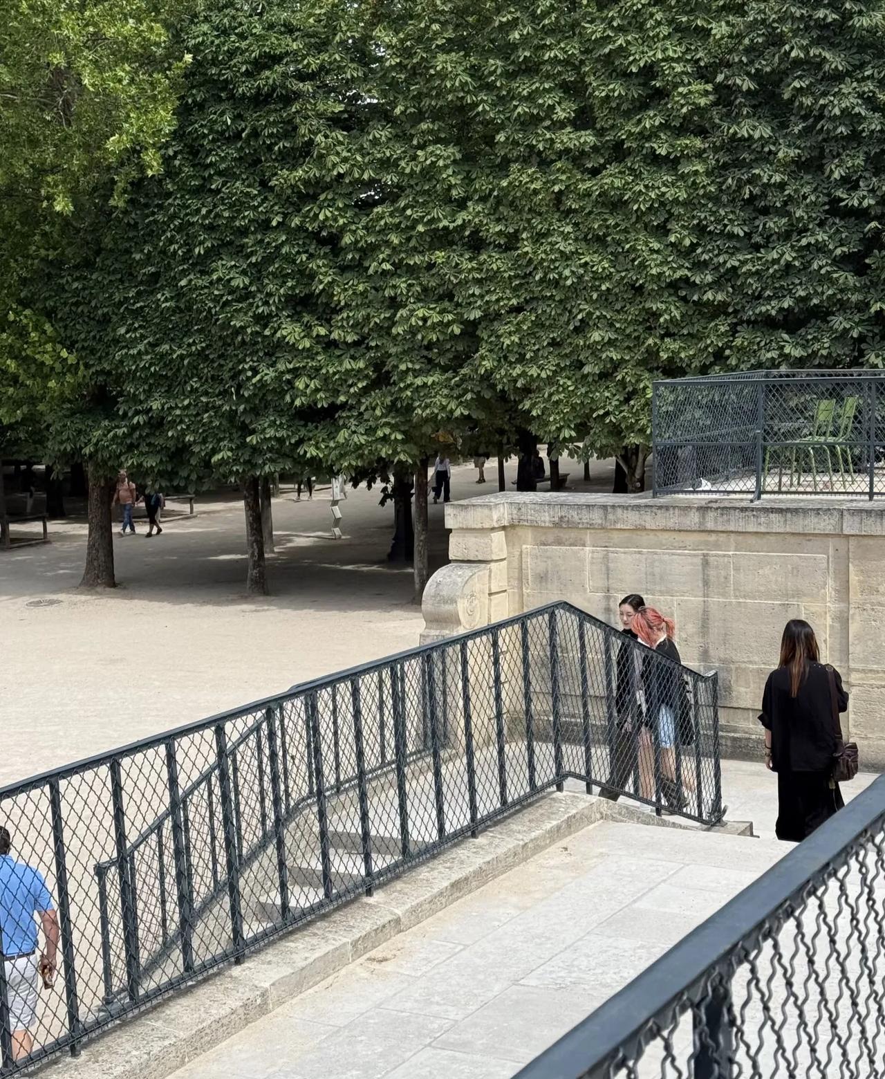 李嫣与好朋友在巴黎杜乐丽花园并肩走着，
黑长直发，
简简单单扎着，
皮肤白净，