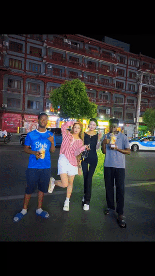 两名年轻女子在街头看到两个黑人男子，竟然主动上前和他们搭讪聊天。
最后还十分高兴