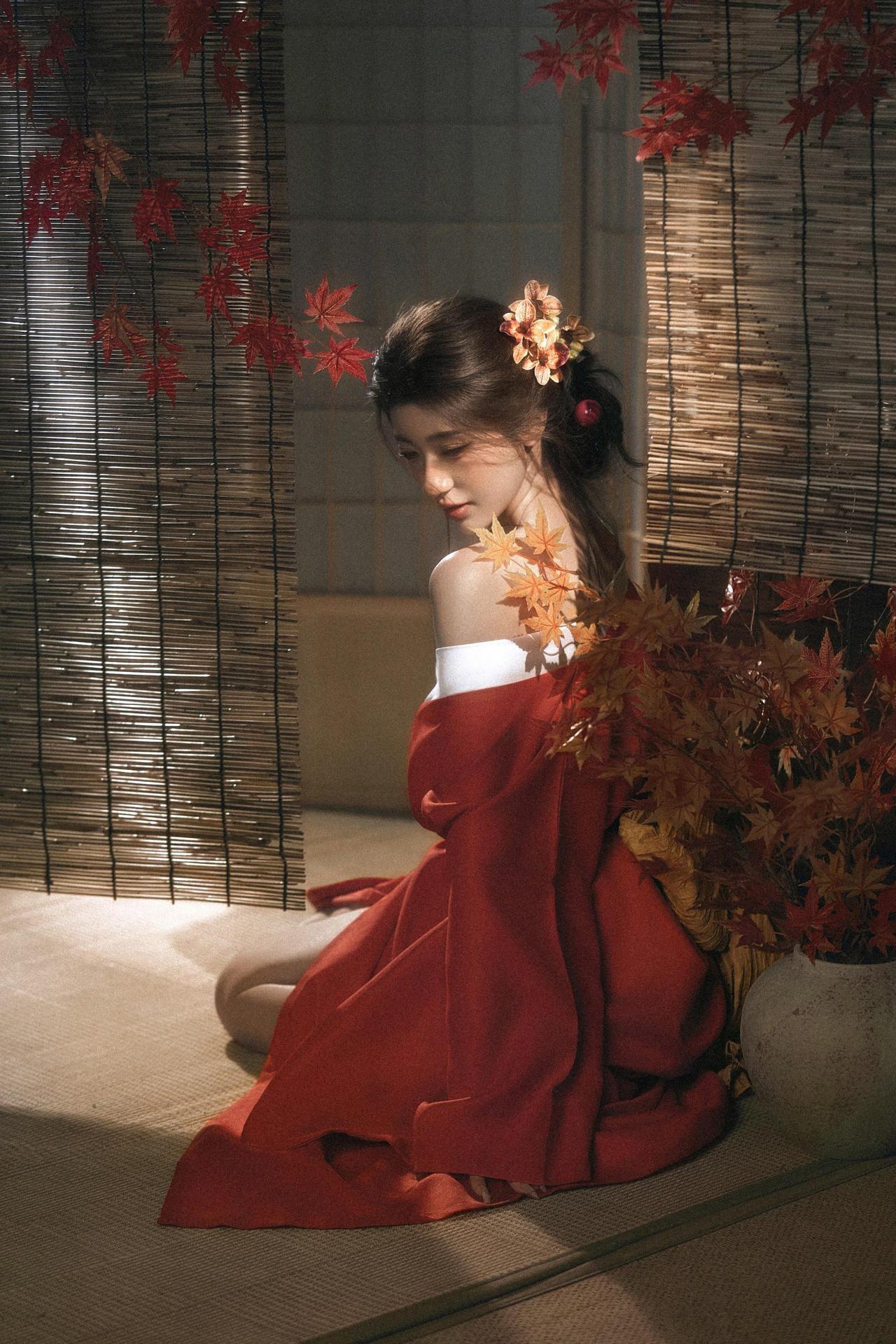 作品的核心优势，在于通过“材质反差”搭建出丰富的视觉层次。竹帘的干硬肌理、红袍的