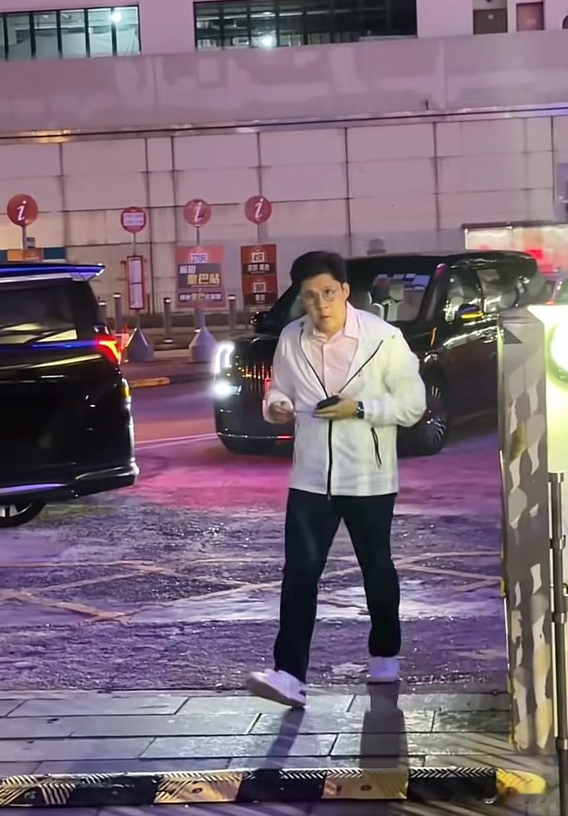 一手拿手机，一手拿小纸片，一个人迈着自信的步伐走进来，身边既没有保镖也没有助理，