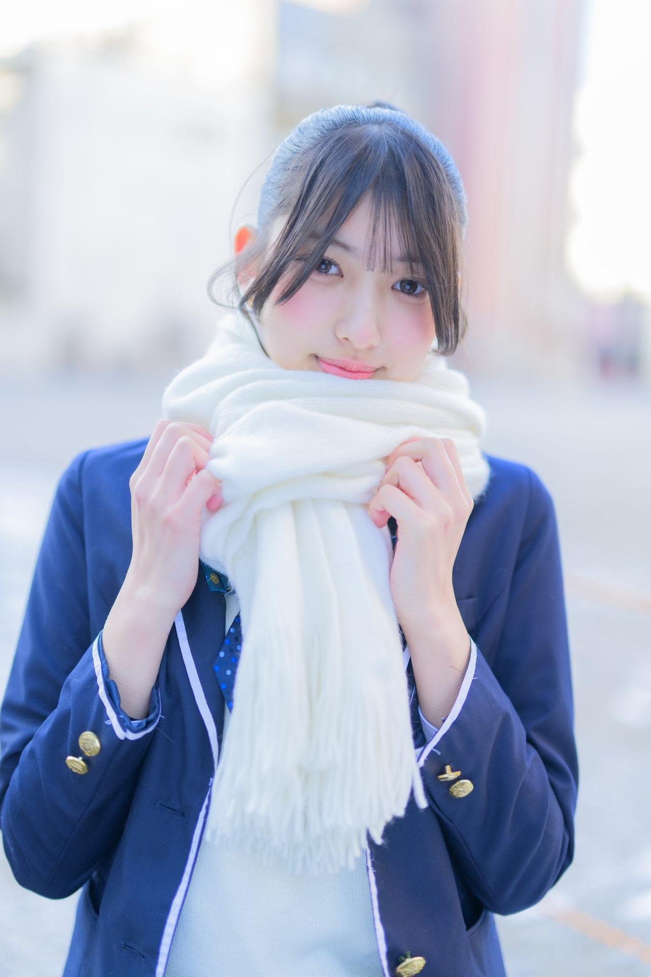 冬日暖阳下，少女轻抚围巾，甜美动人