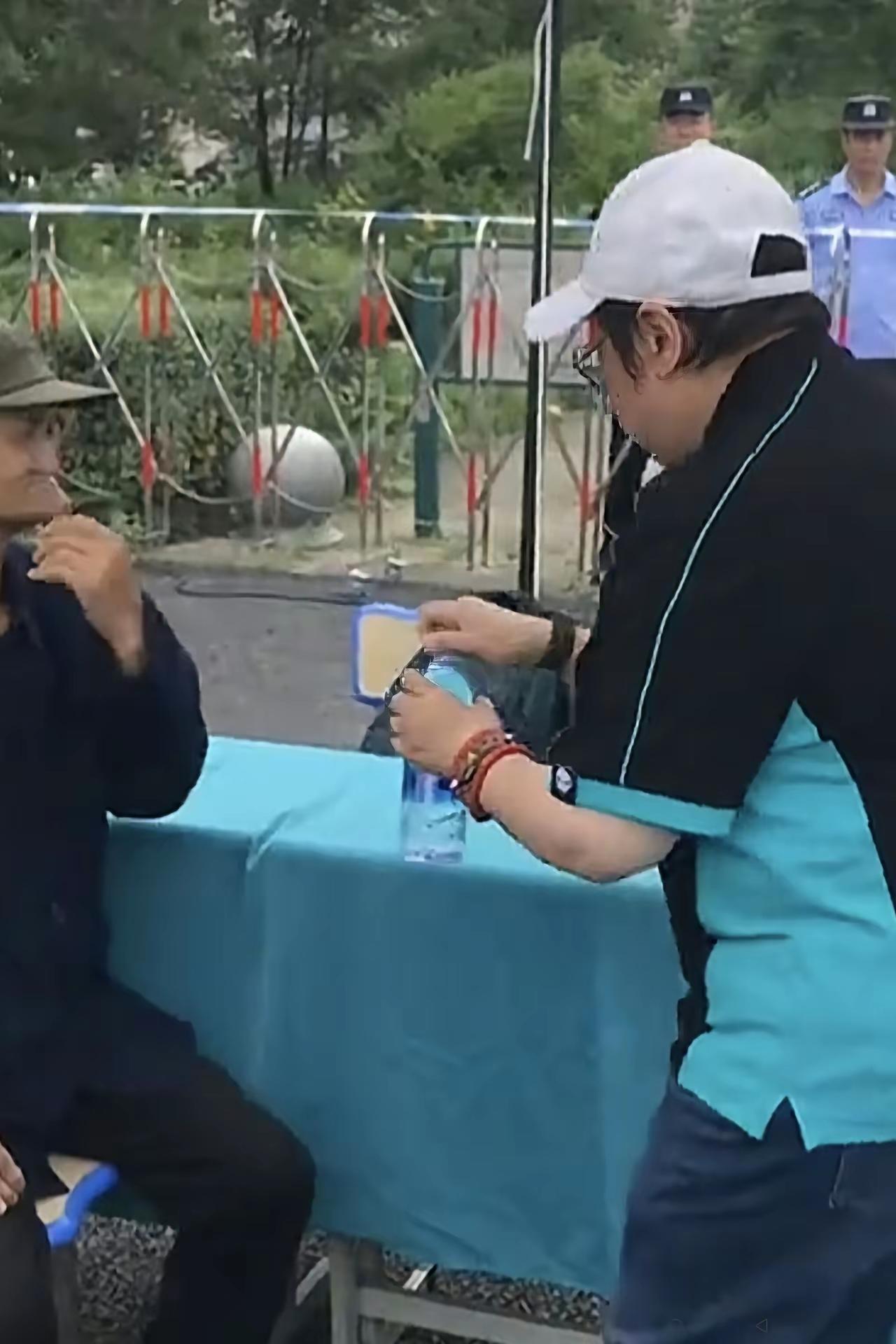 韩红女士在内蒙古搞慈善活动时，看到一位老大爷坐在那里，她赶紧亲自拧开矿泉水瓶盖，