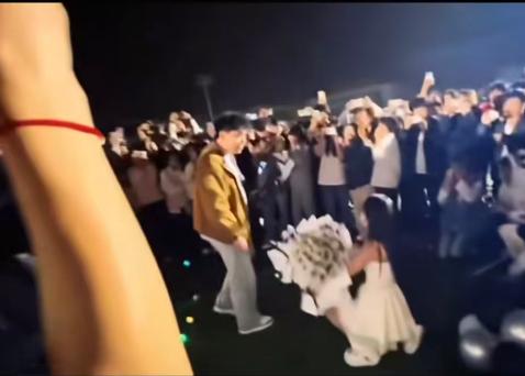 520 这天的校园操场，全是人挤人的热闹。女生穿着白裙子，抱着一大束白玫瑰，在所