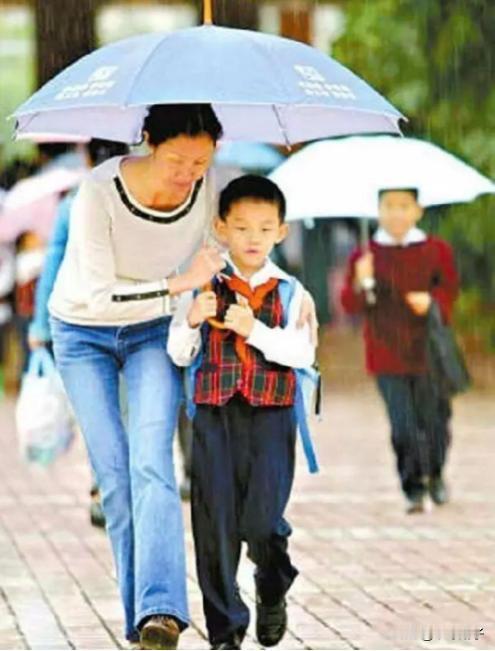 下雨的路上，一位母亲和自己的孩子共用一个伞，为了不让孩子淋着，她接下来的行为让人