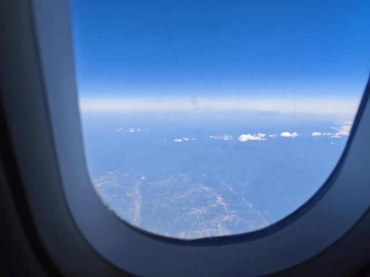 再旅行途中，我在飞机上靠窗的位置拍到了天空的“素颜照”，这蓝得发亮的皮肤，一点瑕