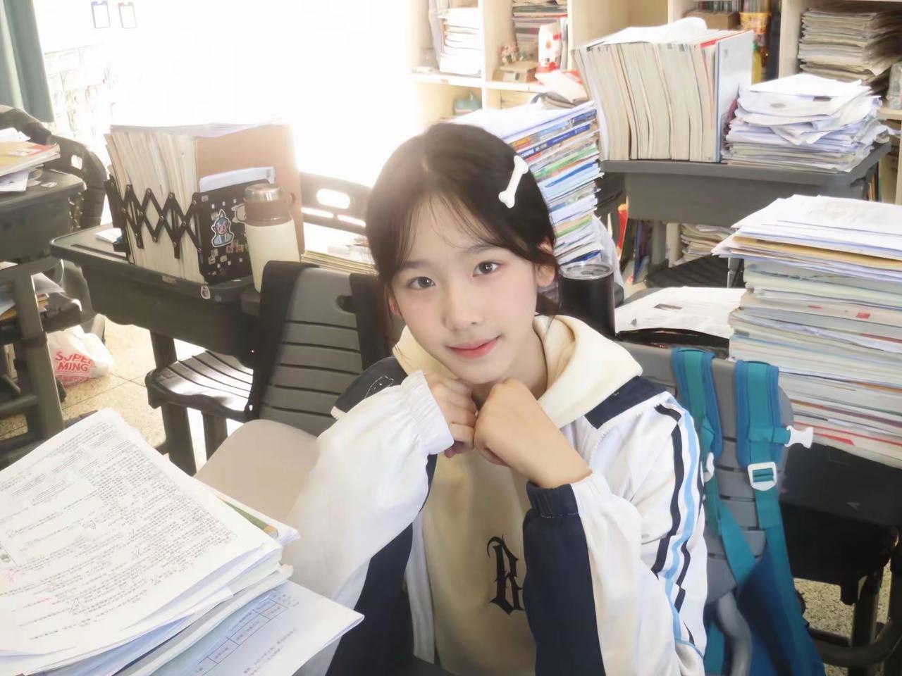 堆满试卷的书桌，阳光穿过窗棂落在肩头。校服外套裹着青春的温度，托腮浅笑，比个剪刀