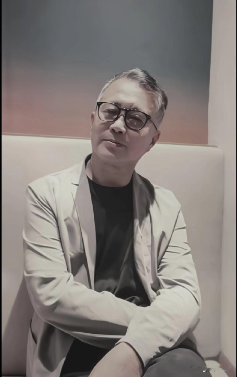 最近网上有张“流浪大师”沈巍近照，他穿上圆领衫灰色西装，文质彬彬的，远看还真有点