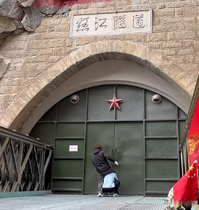 近日，西藏昌都，兄弟俩骑行途经怒江大桥遗址纪念馆，看到门上硕大的五角星上满是灰尘