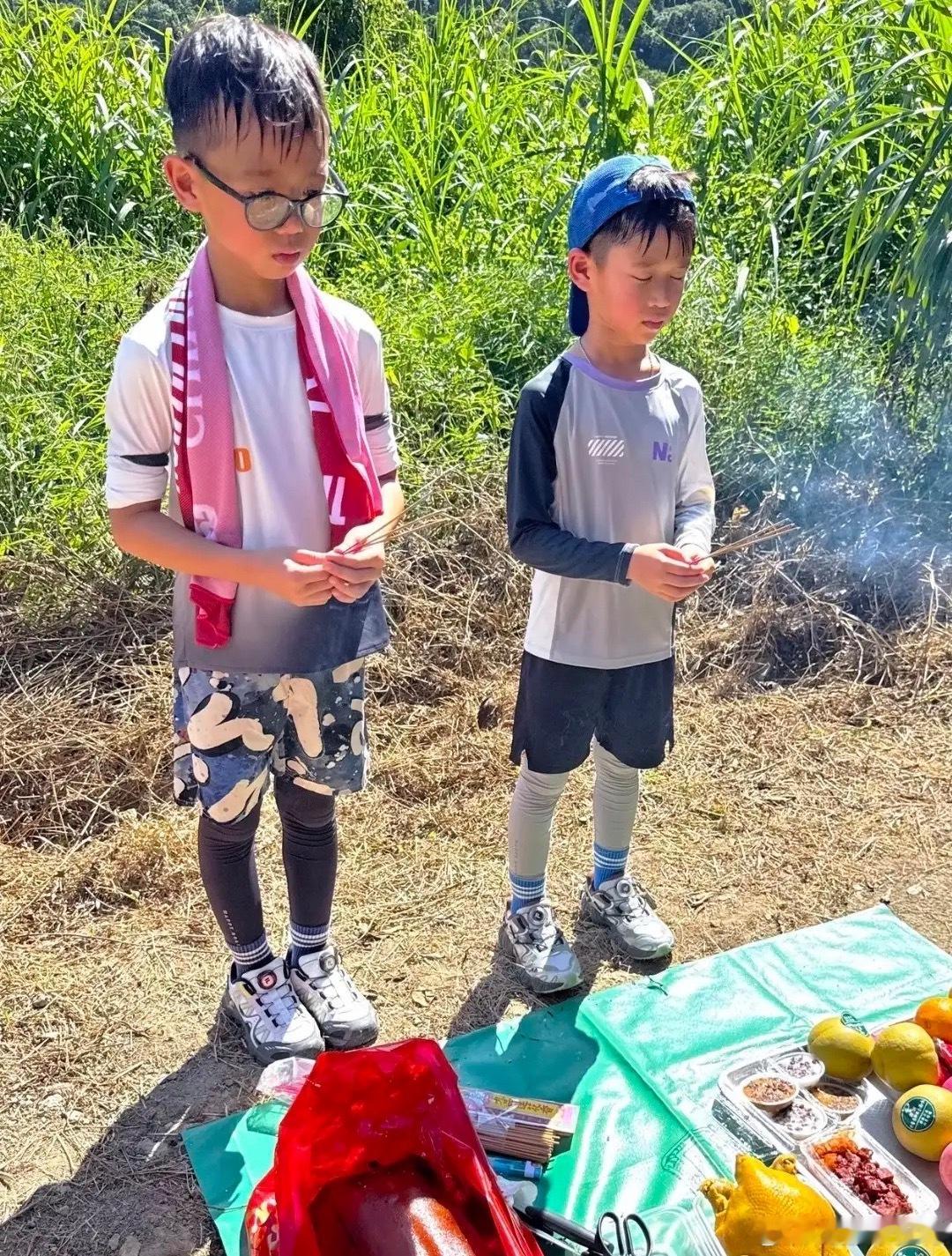 胡杏儿老公带着两个儿子祭祖，客家人重阳要拜山，地上摆满了水果烧鸡等贡品，9岁李奕