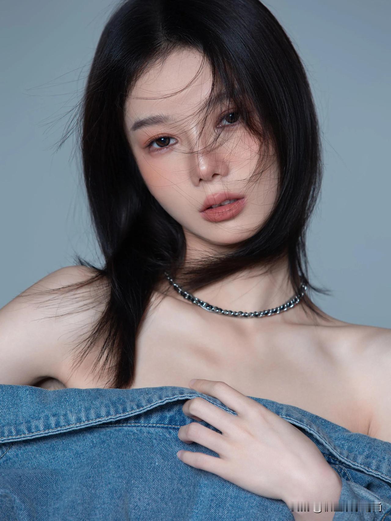 这件牛仔外套被赋予独特演绎，宽大的衣身随意地滑落至肩头，露出光洁曼妙的肩线。牛仔