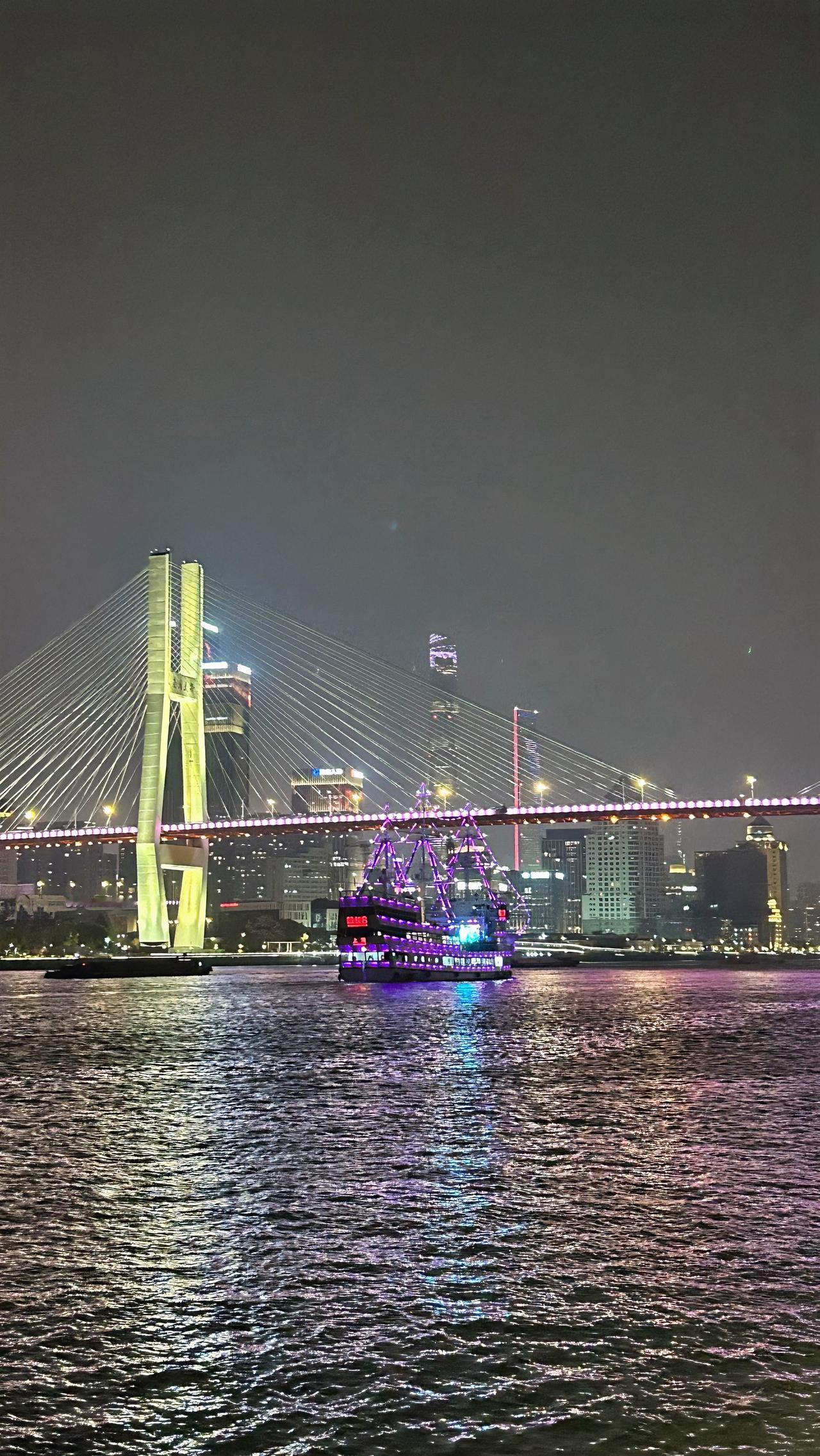 城市中的夜景上海黄浦江南浦大桥处的夜景。江水波光粼粼，五彩缤纷的游轮奏放着悠扬动