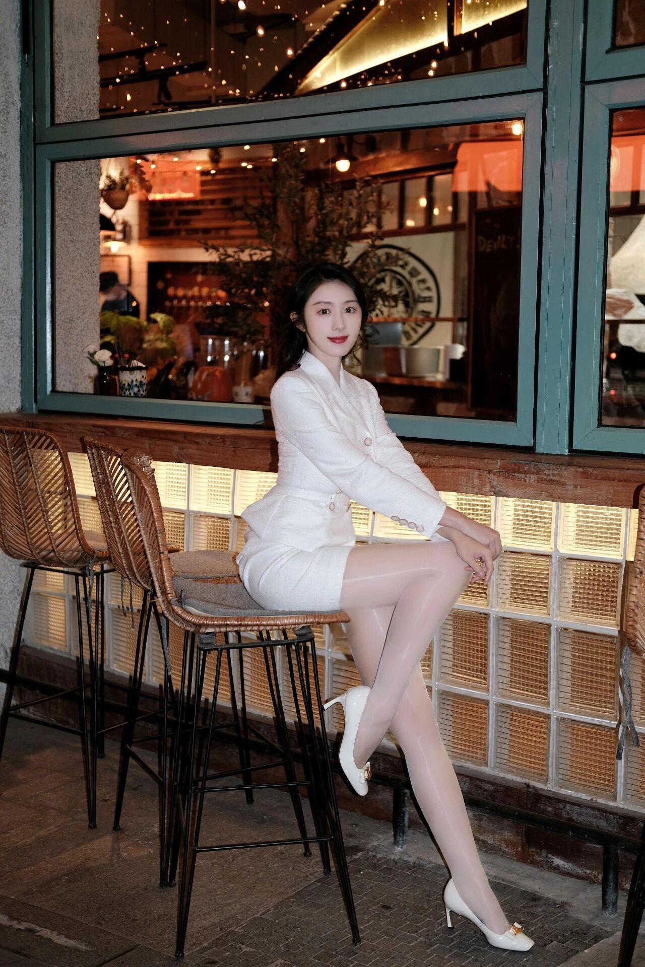 《午后咖啡馆的剪影》
阳光斜斜切过浅米色方格砖墙，在落地窗上折射出细碎光斑。她端