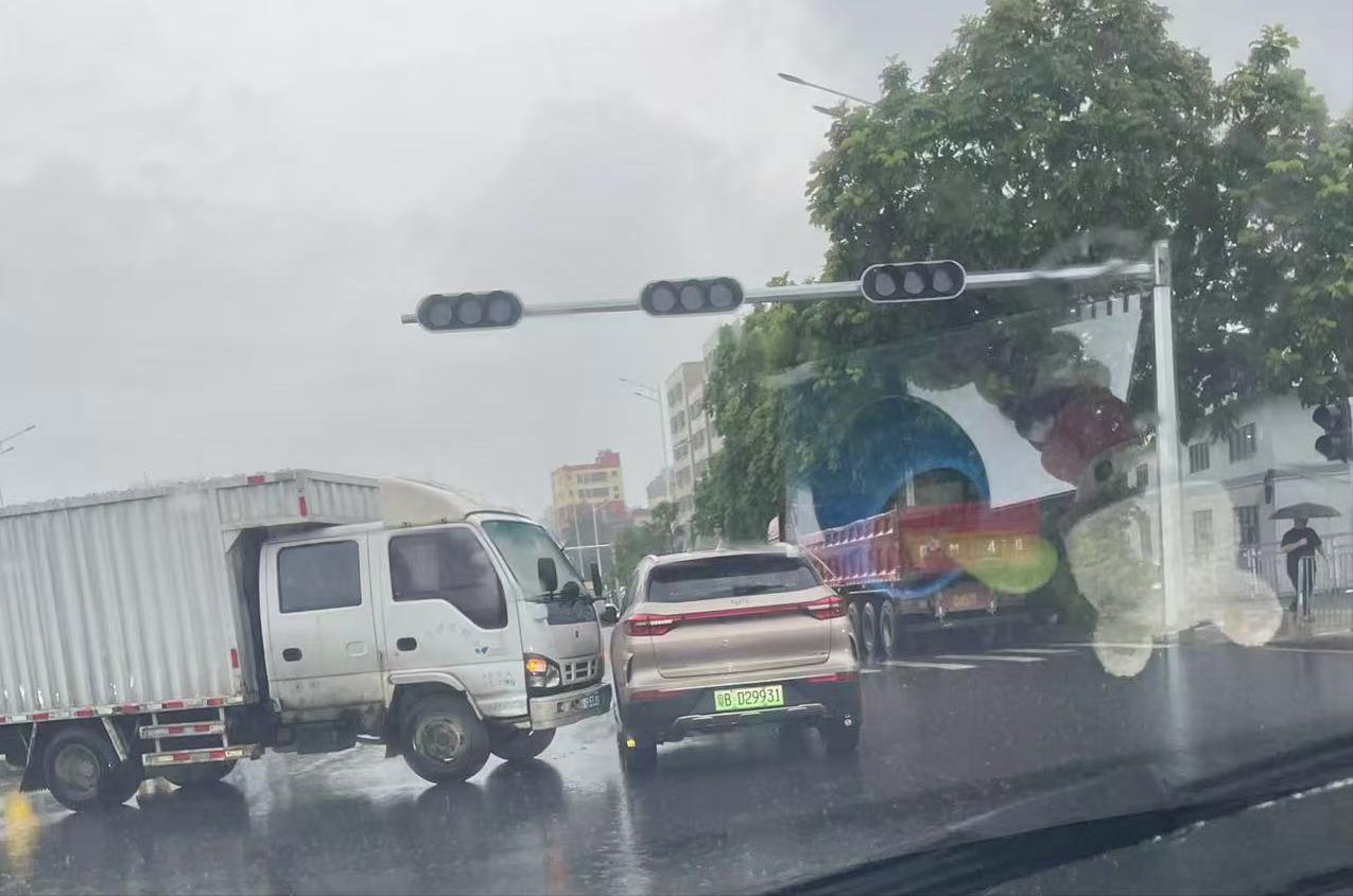 今天，阴沉的天空飘着细雨，红绿灯路口一辆货车和一辆SUV发生了轻微擦碰。本是一句
