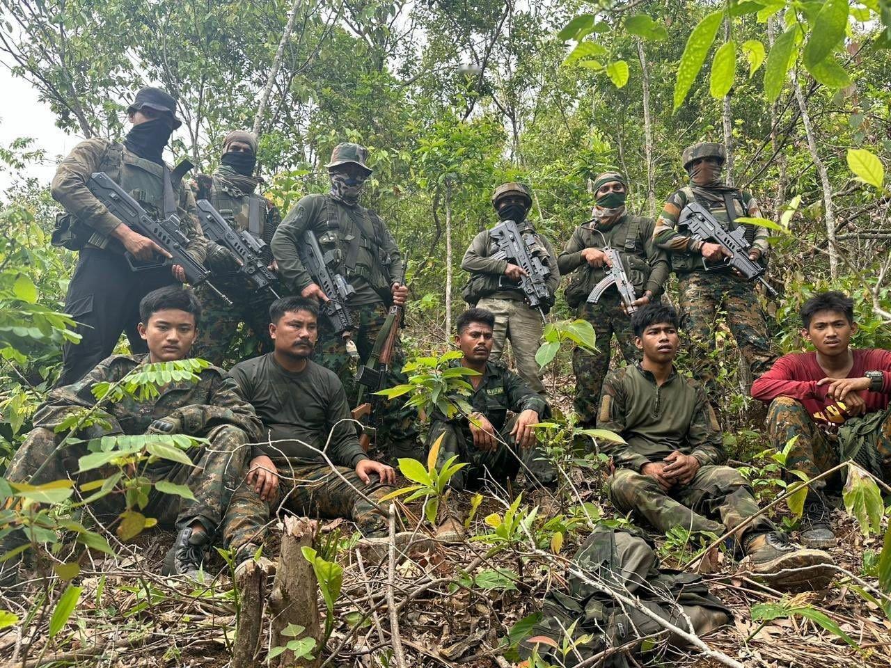 照片中21名印度陆军特种部队伞兵身穿迷彩服，手持塔沃尔步枪，站在几名坐在地上、手