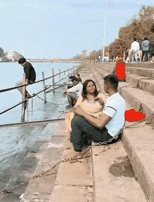 岸边台阶上做着一对小夫妻，从画面上感觉到，好像是在争执什么？突见女子众身跳入滾滾