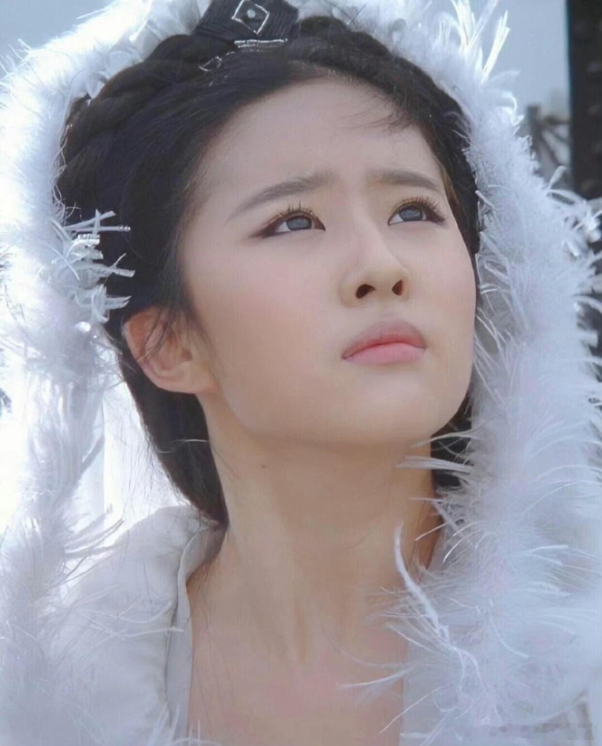 刘亦菲版小龙女的经典白衣造型，主体服饰是一袭月白广袖古装，清透如月光，衬得她身形