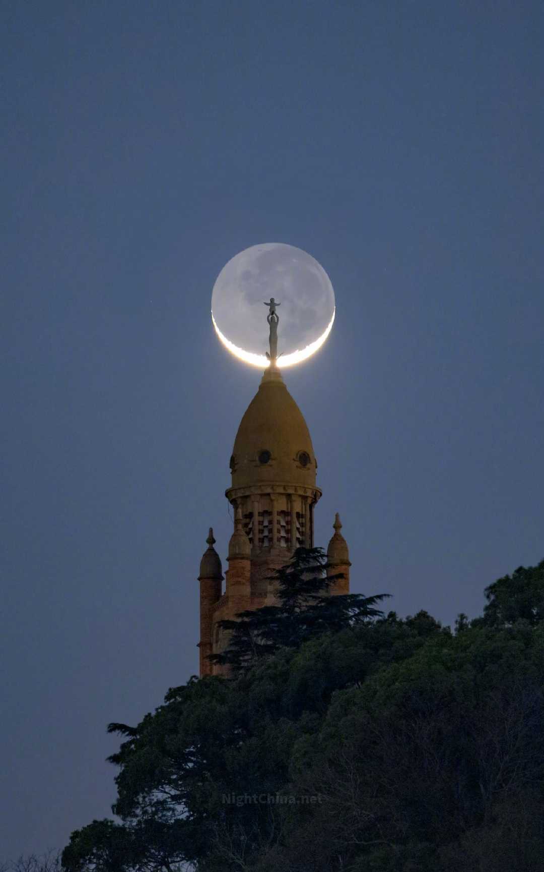 月牙轻轻托起了塔尖上的圣像，仿佛天地之间早有约定。那一弯新月既是光的边缘，也是黑