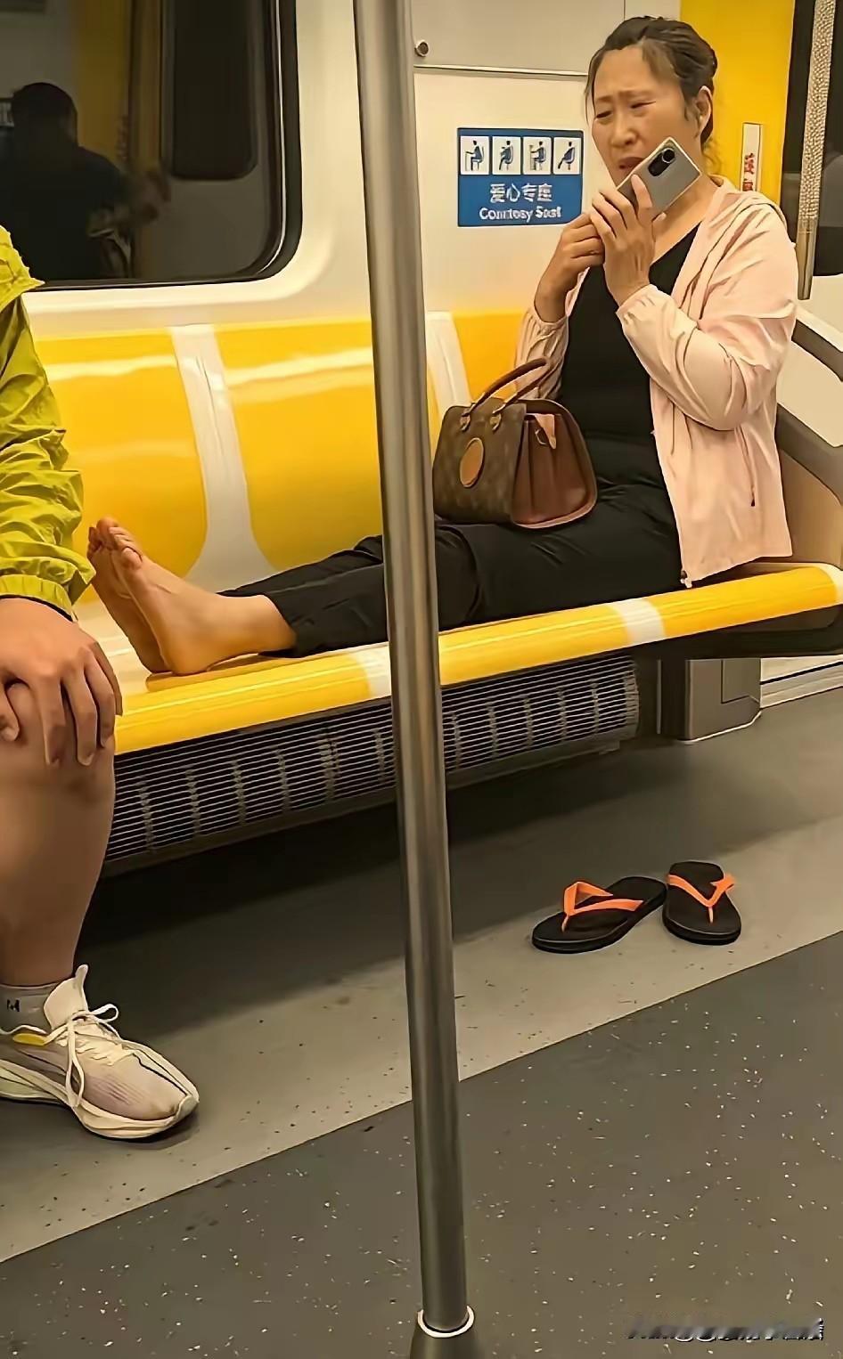 大妈在地铁上真惬意，脱了鞋坐在爱心专座上，还光个脚丫子，这是把地铁当家了，怎么舒
