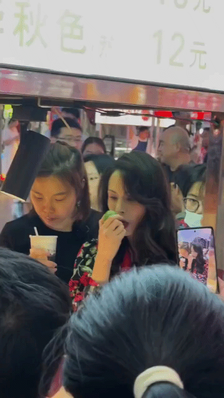 李若彤出席活动，被身旁的姑娘抢镜。

活动现场，李若彤一头波浪形卷发，大花上衣，
