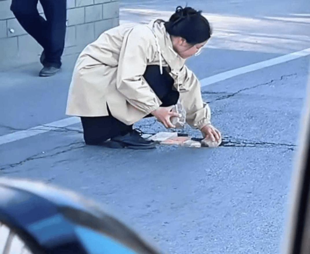 河南郑州，正值上班高峰期，一个年轻女孩拿着砖头躲在了墙边，路人以为她要做出一些不