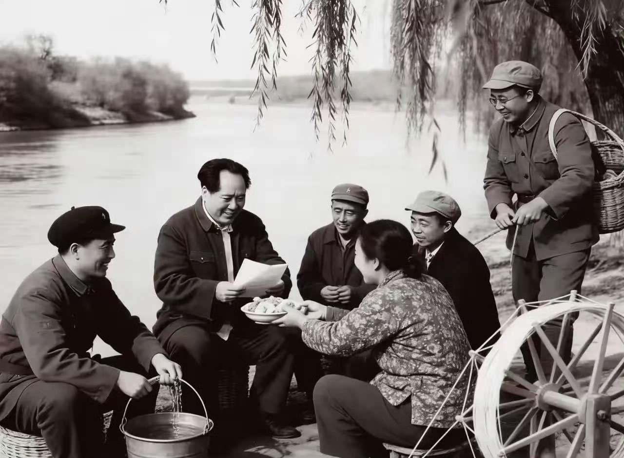 这张照片曾让无数人动容：河边垂柳下，毛主席与乡亲们促膝而坐，一位大姐端着吃食，眼