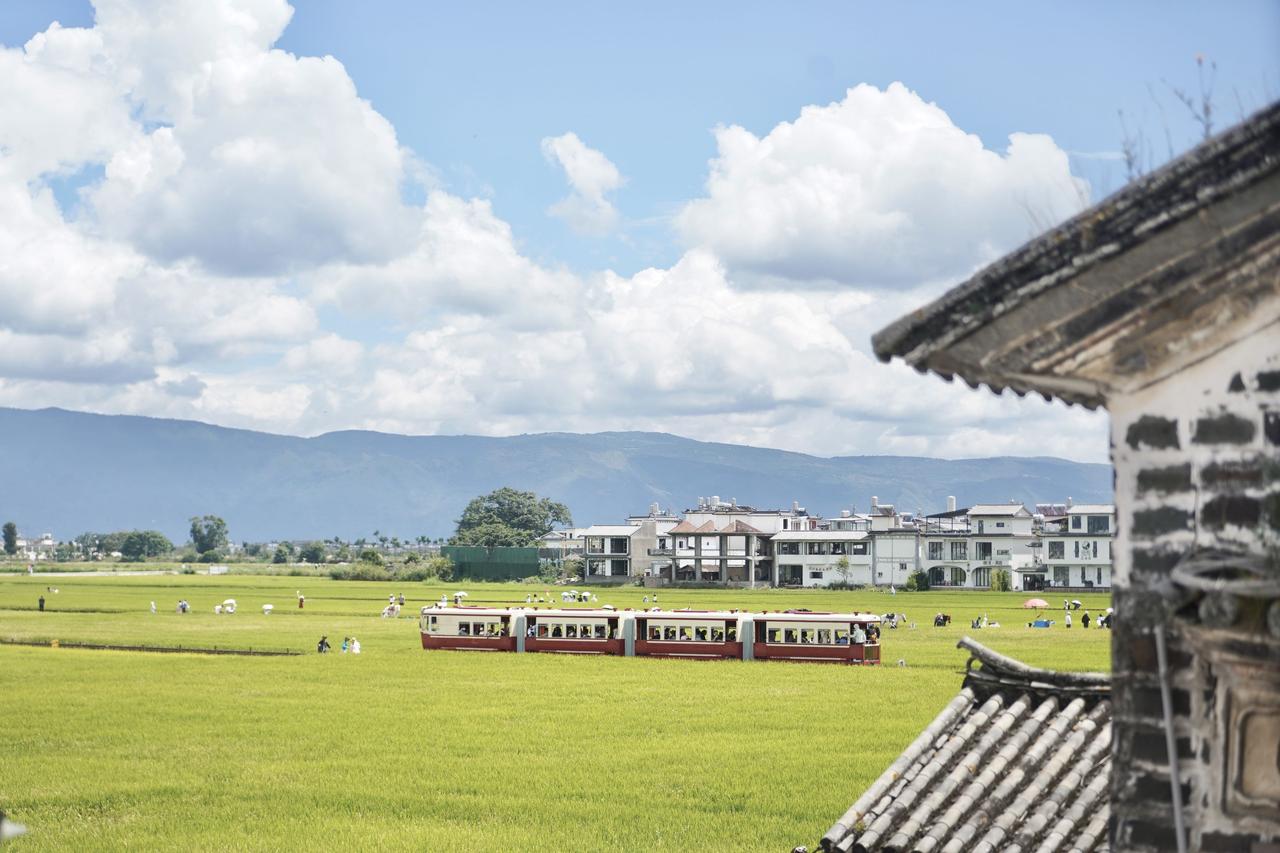 在大理的喜洲，时间是应该被定格的美好。远处白族民居的飞檐勾勒出天空，小火车穿行在