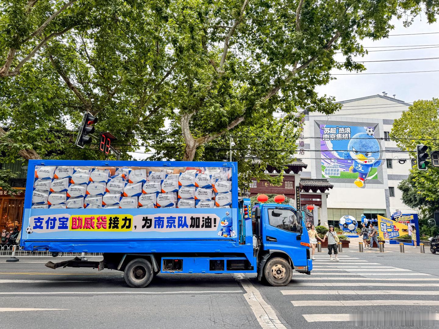 百店发支付宝助威袋为南京队加油偶遇就会有惊喜！十万个“苏超”助威袋的卡车来到南京
