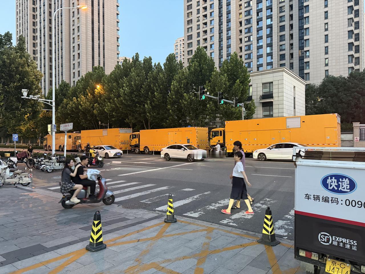 繁忙街头的快递车与行人交织，城市生活节奏快。城市道路景象 路过的快递小哥 路过的
