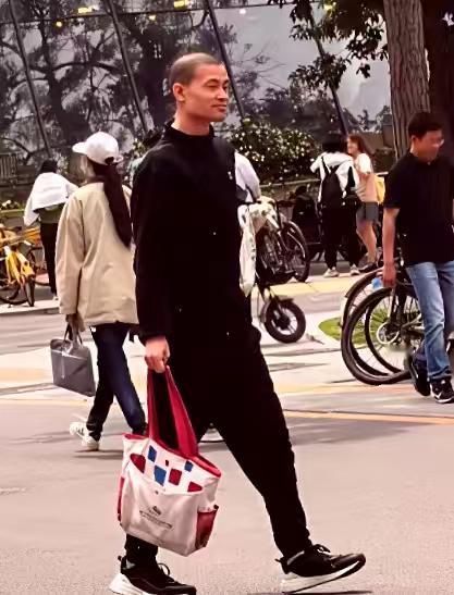 一个包、一头短发、几件休闲衣，竟能让网友吵起来。  
有人嫌他不像“北大教授”。