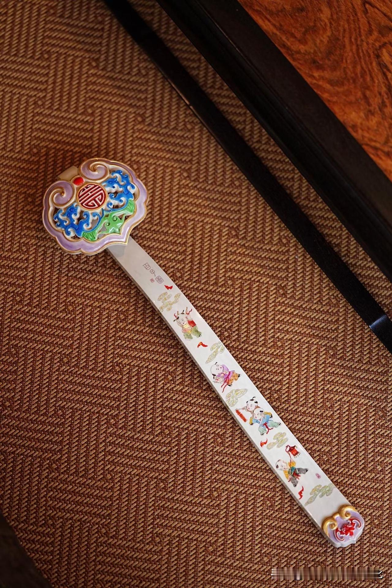 这一柄如意，看似热闹，其实很静。

百子入纹，人物细若游丝，却各有神情，
不是堆