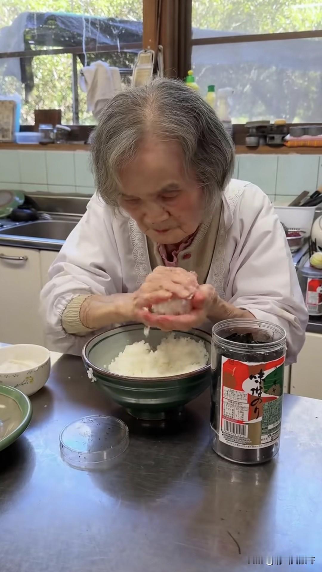 这是一位日本90多岁的老人工作的情景，饭团、配料就直接用手抓，而且还不戴口罩，这