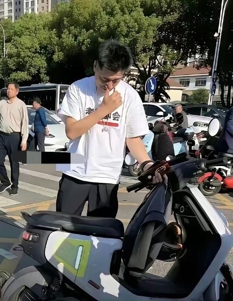 这辆电动车，它就那么安安静静地停在那儿。车座椅上还搁着个头盔，挡风被也还好好地挂