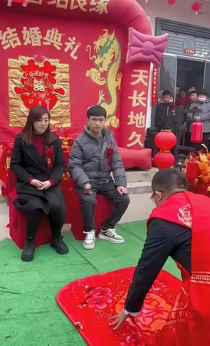 新郎已经完成了婚礼仪式，然而站在他上方的年轻男子显得比新郎更年轻，这不禁让人好奇