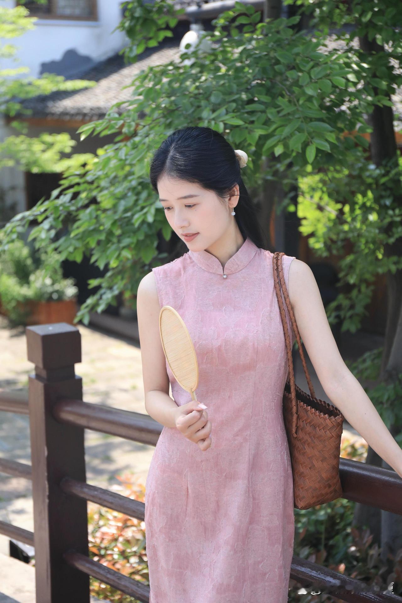 粉裙少女漫步古风庭院，手持团扇，优雅动人。