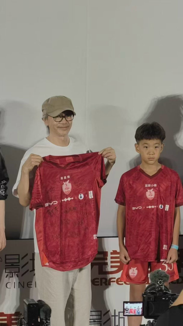 星爷路演和足球少年聊天好温柔周星驰与足球少年定下世界杯约定 路演现场，足球少年穿