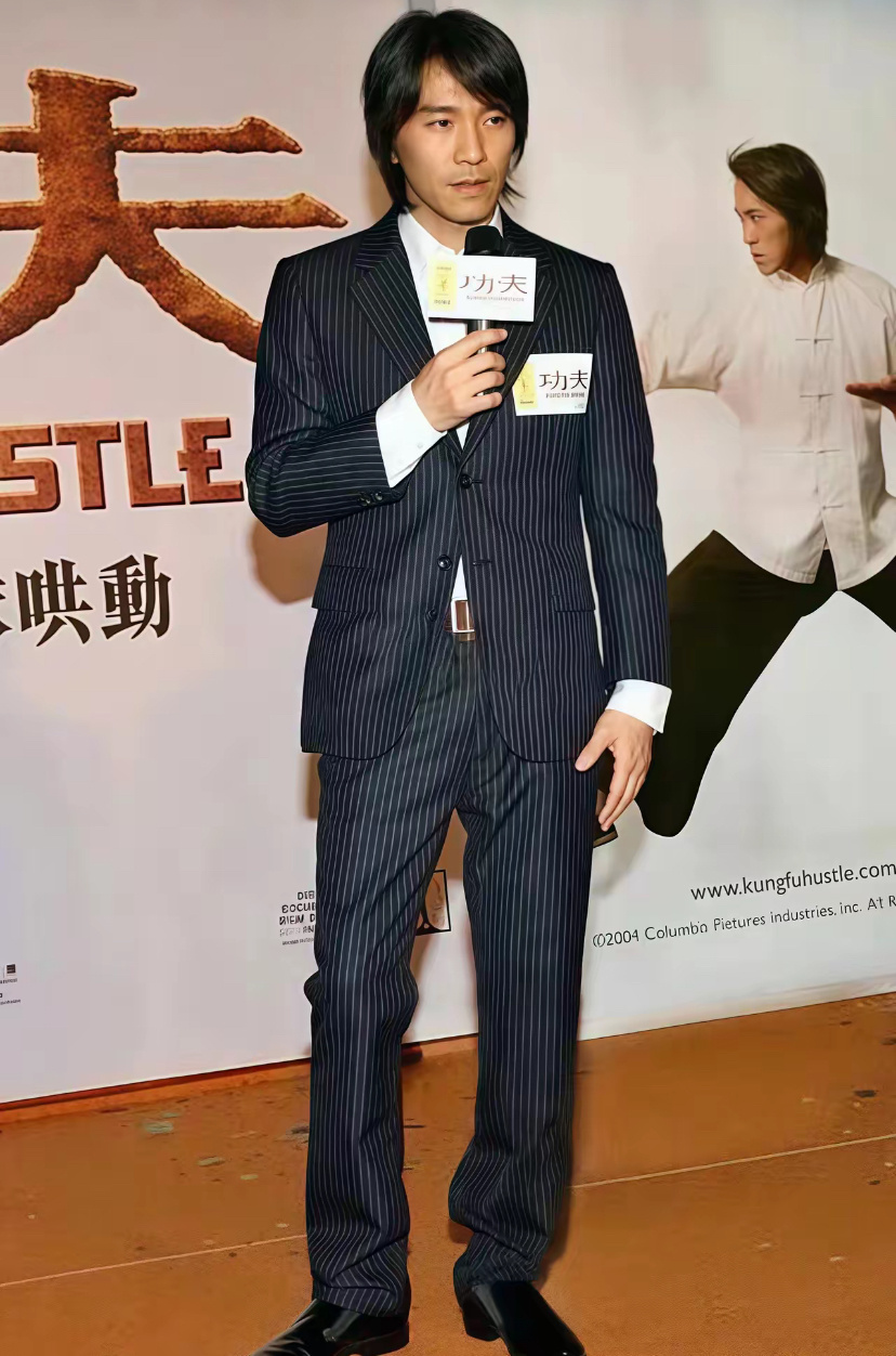 2004年电影《功夫》香港首映礼时周星驰身穿一身蓝色条纹西装内搭白色衬衫，脚上穿