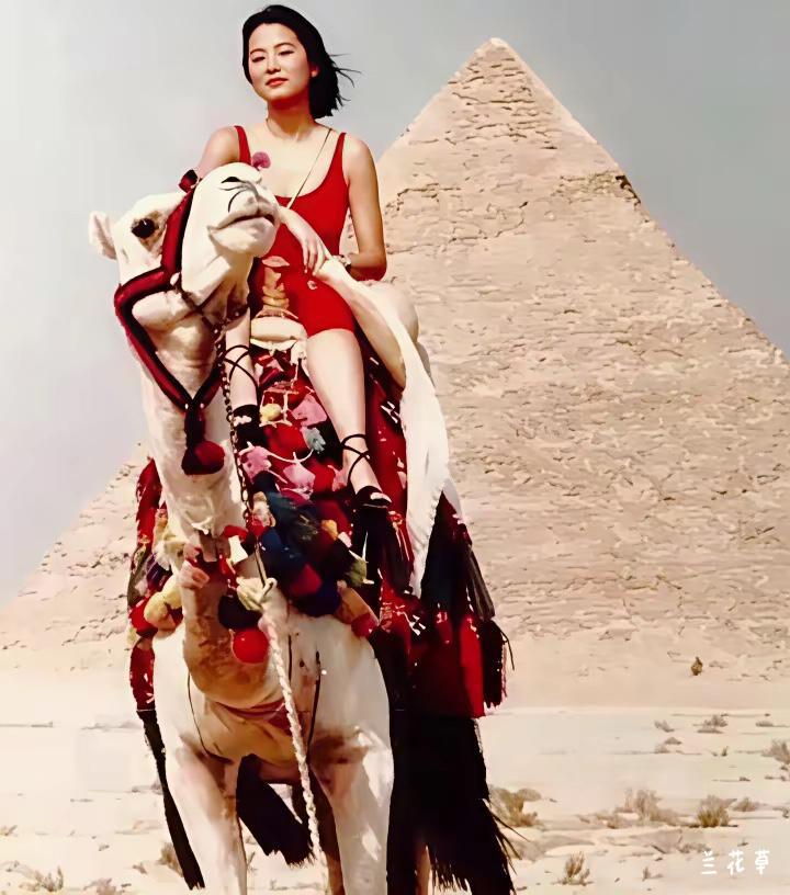 林青霞骑骆驼于埃及金字塔前的留影。
一袭的红色给单调的沙漠画面增添一抹滋润的色泽