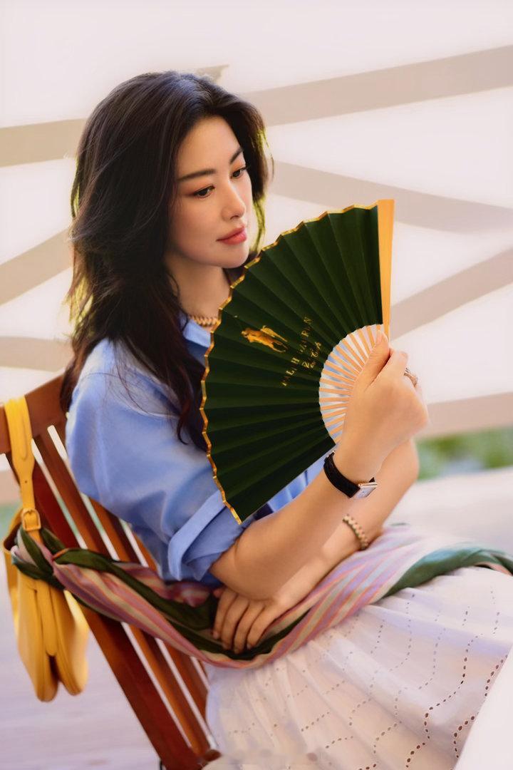 朱珠被晒红了 她穿白裙站在阳光下的那张图，皮肤被晒得微微发红，发丝被风吹起来。没